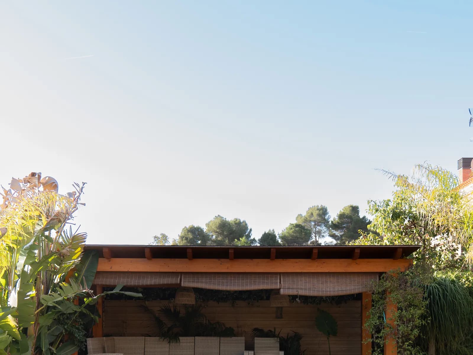 Porche exterior con cocina, piscina y vegetación