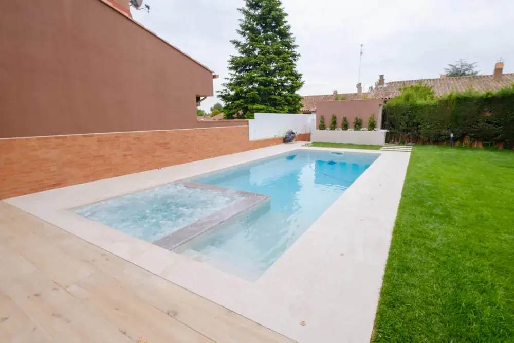 Vista general de piscina residencial con zona de estancia