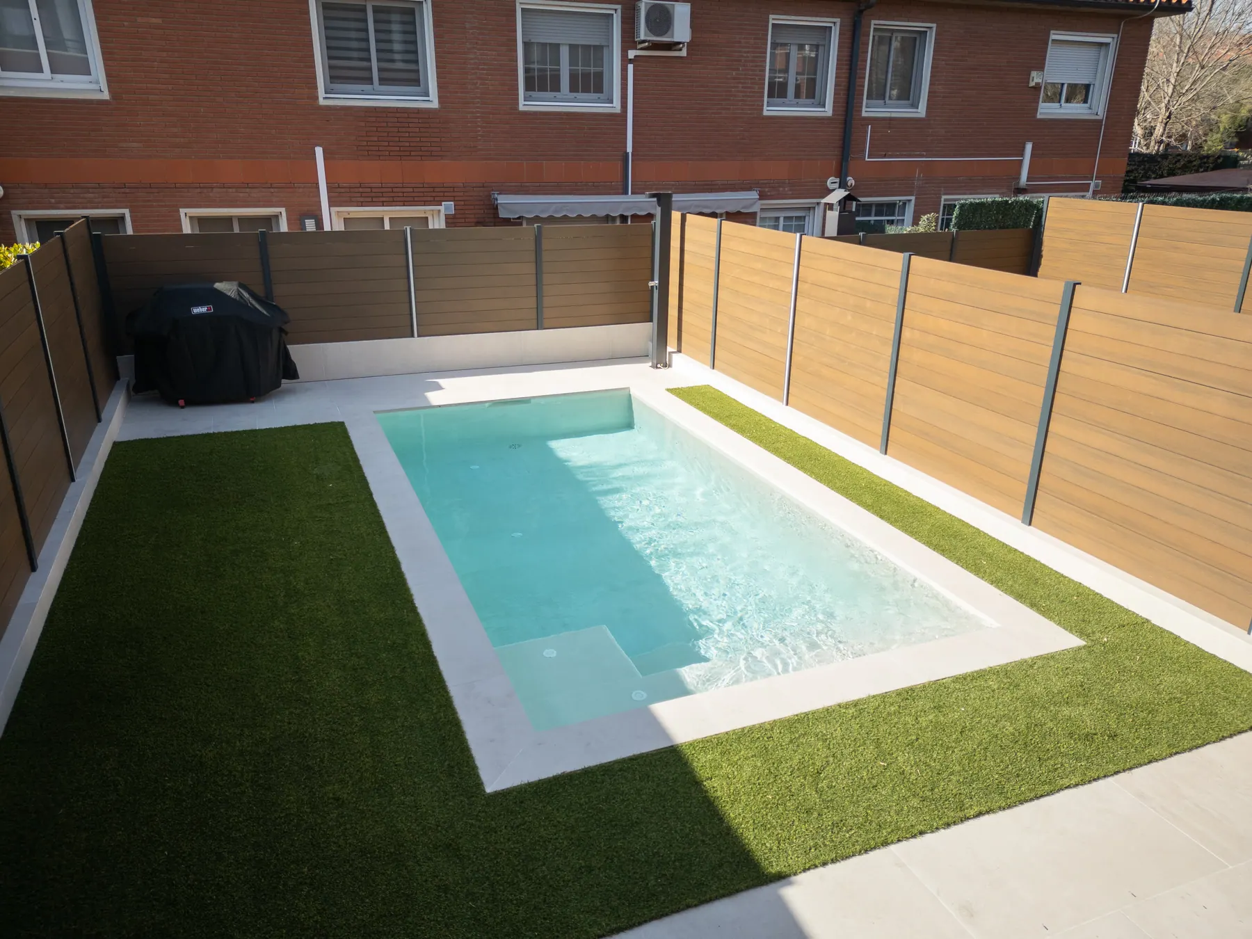 Vista aérea de piscina con césped artificial y pavimento exterior