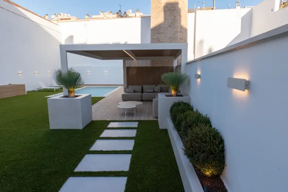Recorrido exterior con apliques y jardineras iluminadas