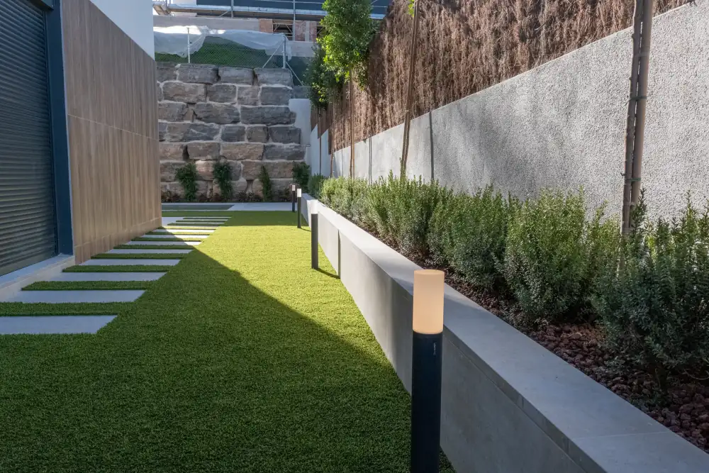 Baliza integrada en jardinera junto a zona de paso exterior