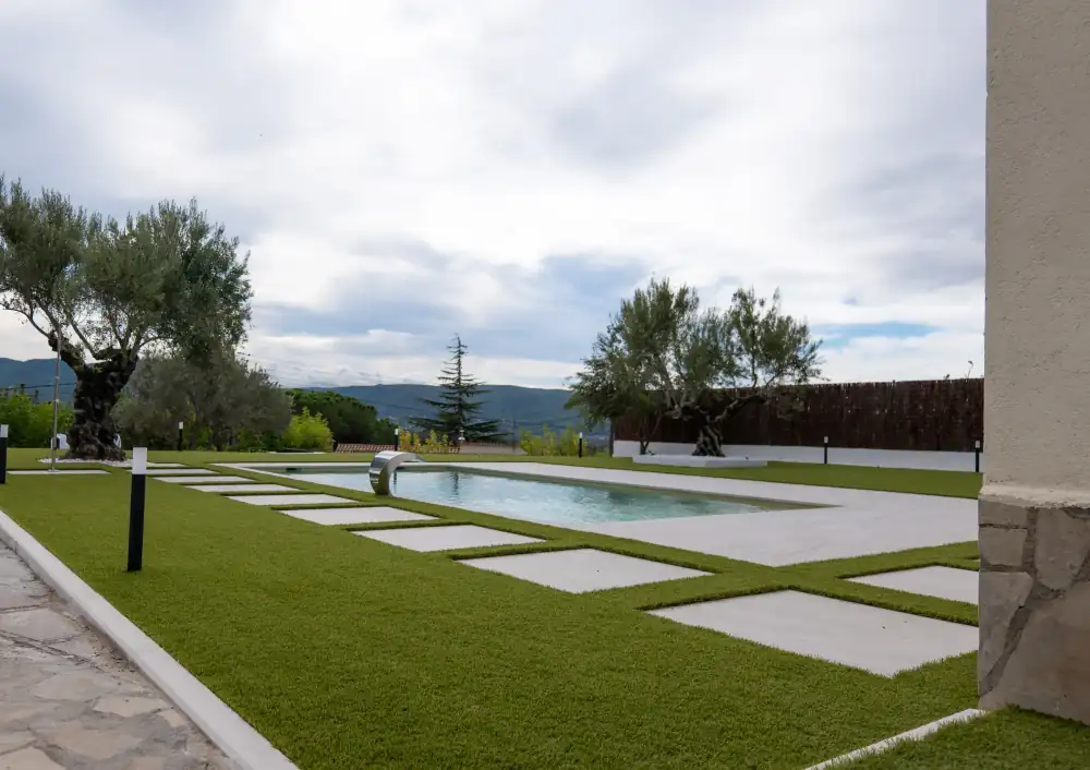 Exterior residencial con pavimento, jardín y balizas
