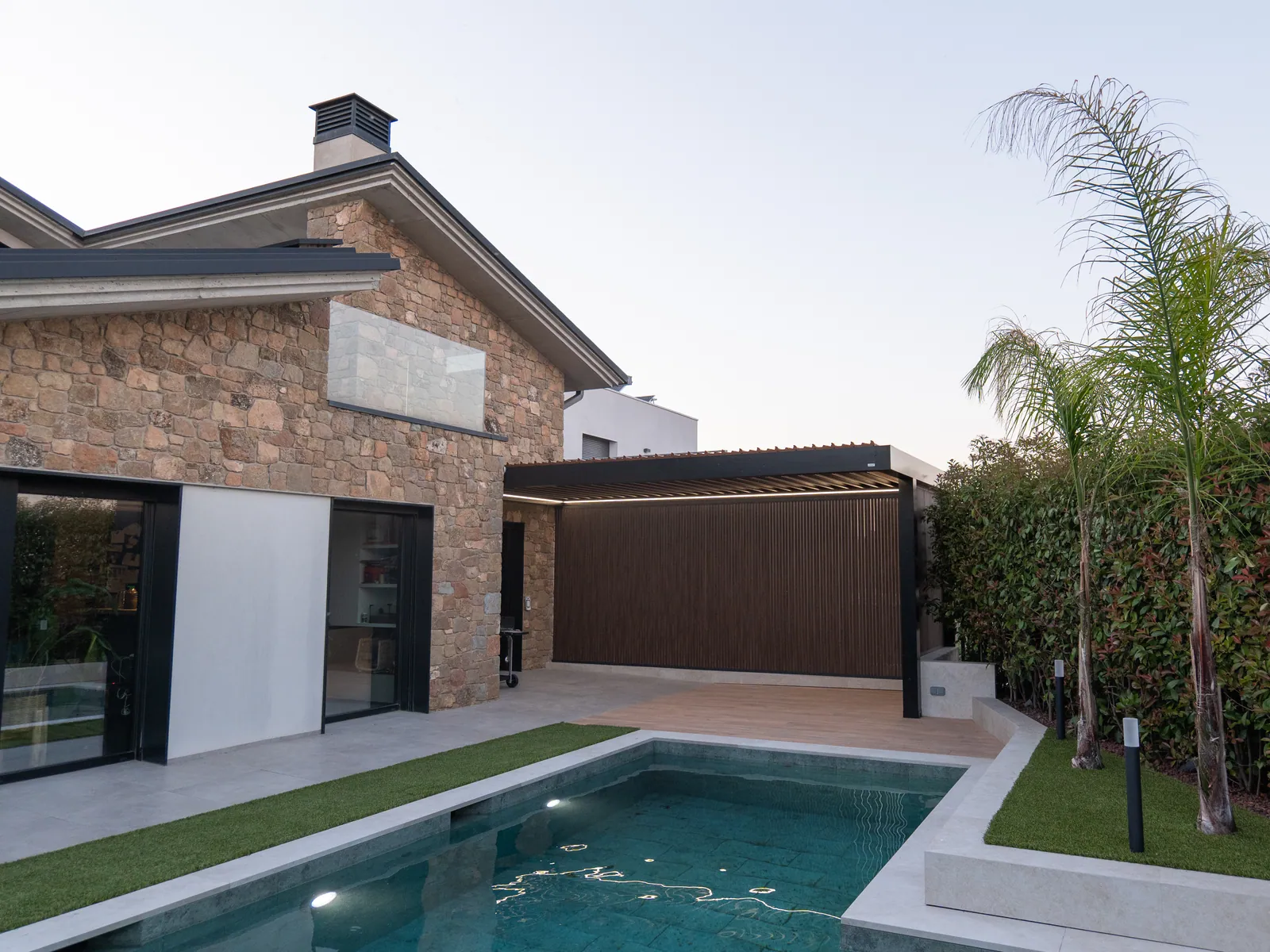 Piscina y zonas verdes integradas en jardín residencial