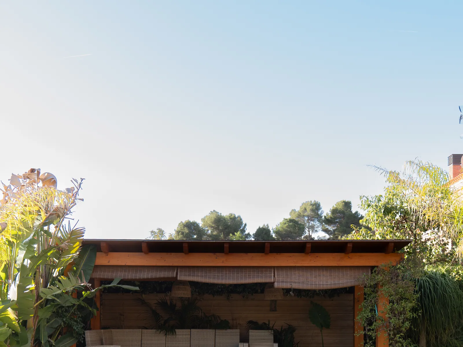 Porche exterior con cocina, piscina y vegetación