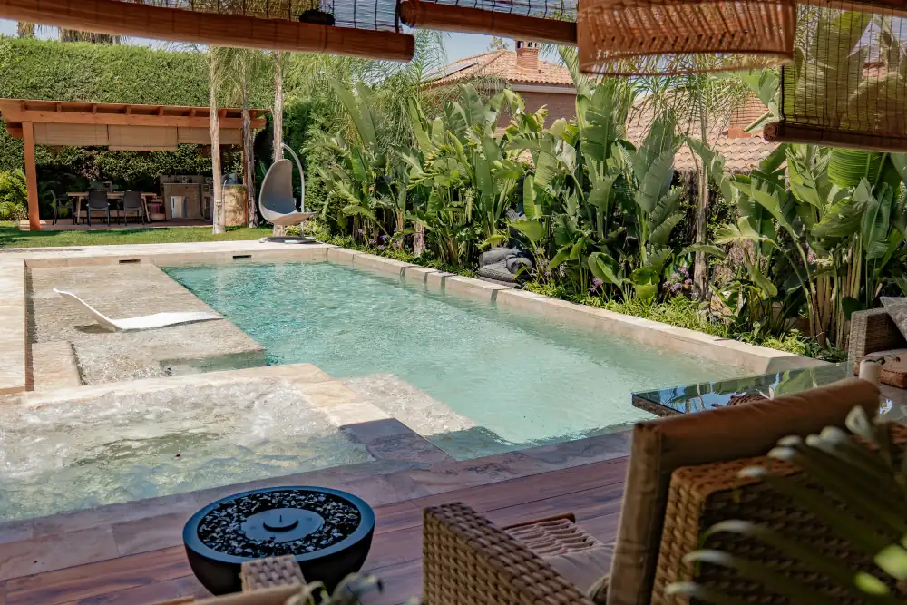 Zona lounge junto a piscina y pérgola dentro de una obra exterior integral