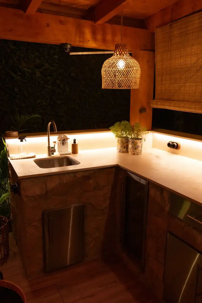 Cocina exterior de obra con iluminación integrada y acabados duraderos