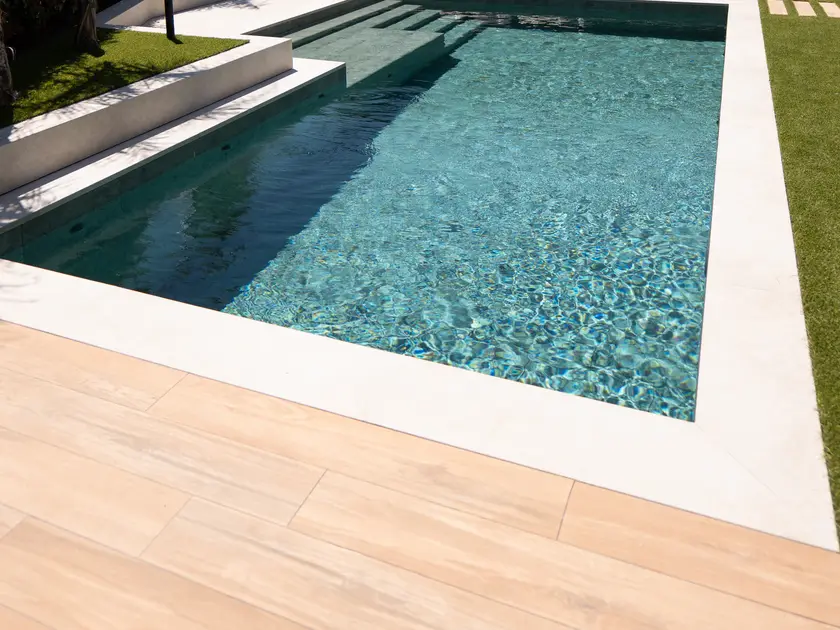 Piscina y pavimento exterior en un jardín de Agramunt