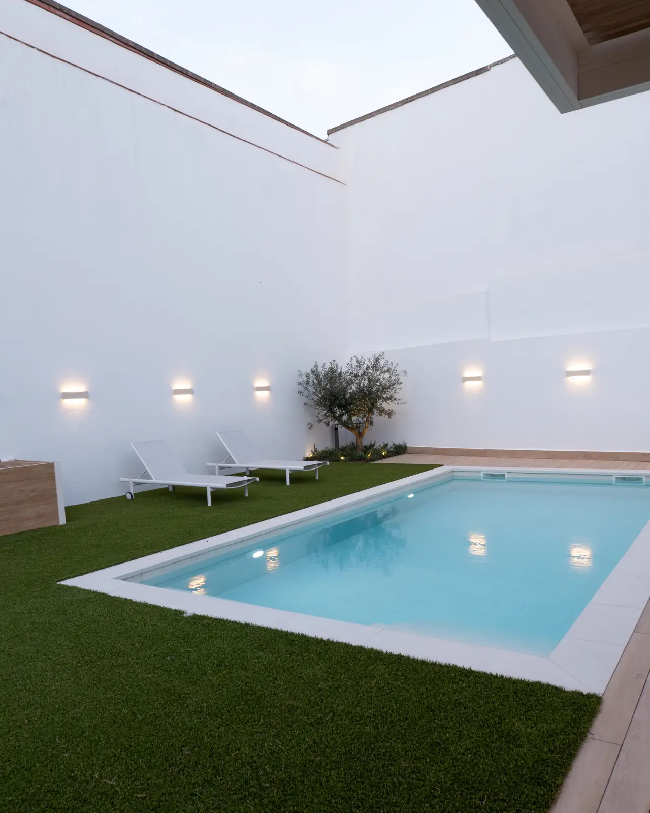 Piscina de obra a medida integrada en jardín residencial