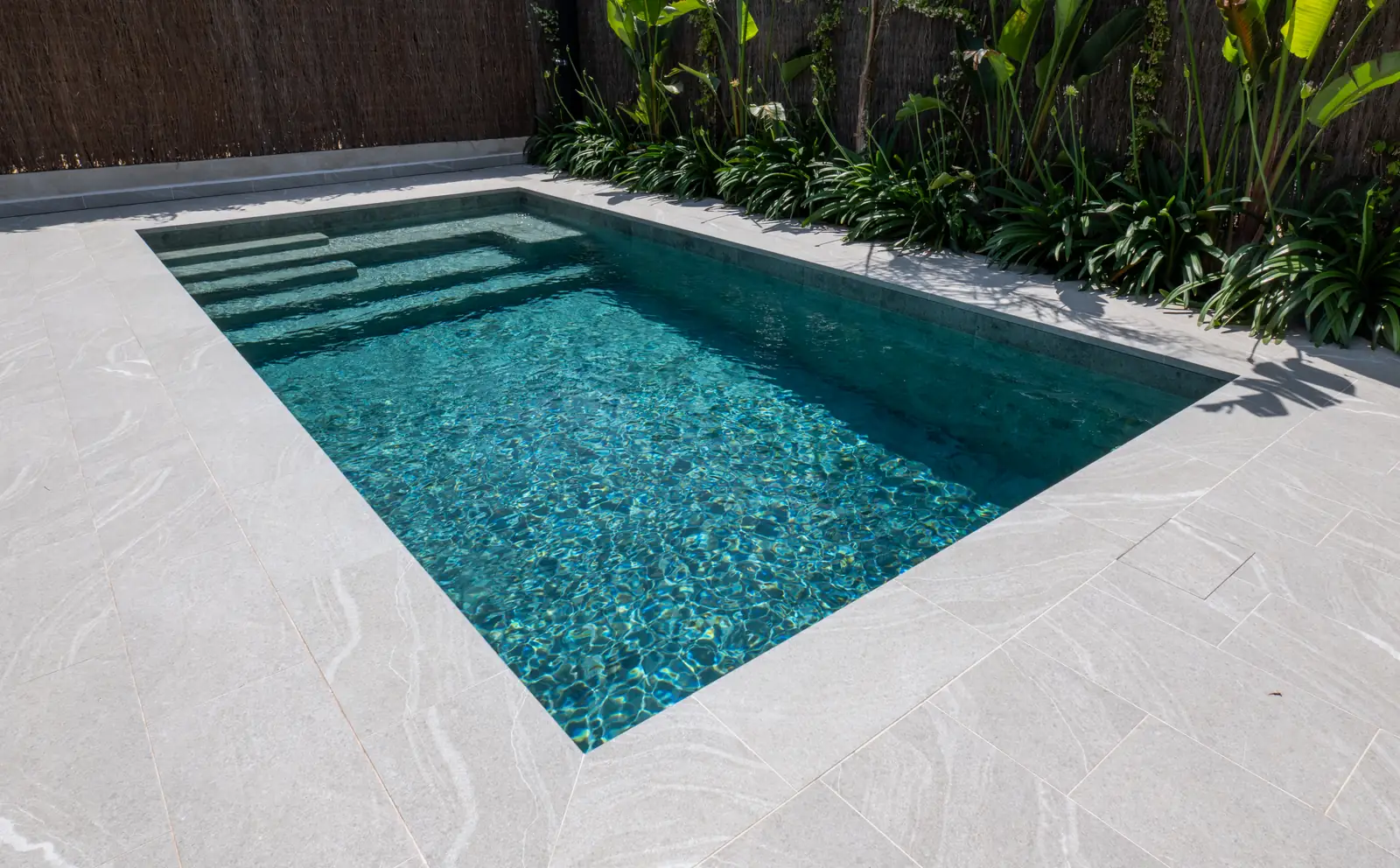 Piscina de obra con escalera integrada y vegetación perimetral