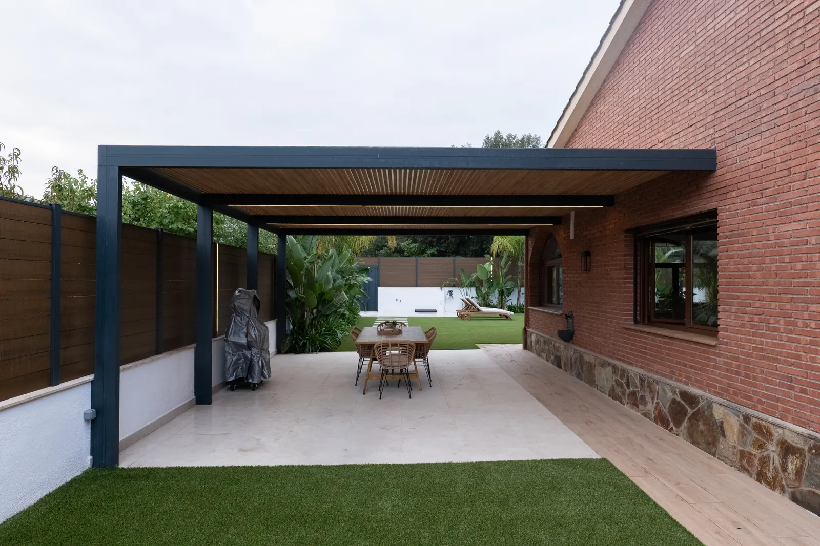 Pérgola integrada en vivienda con comedor exterior
