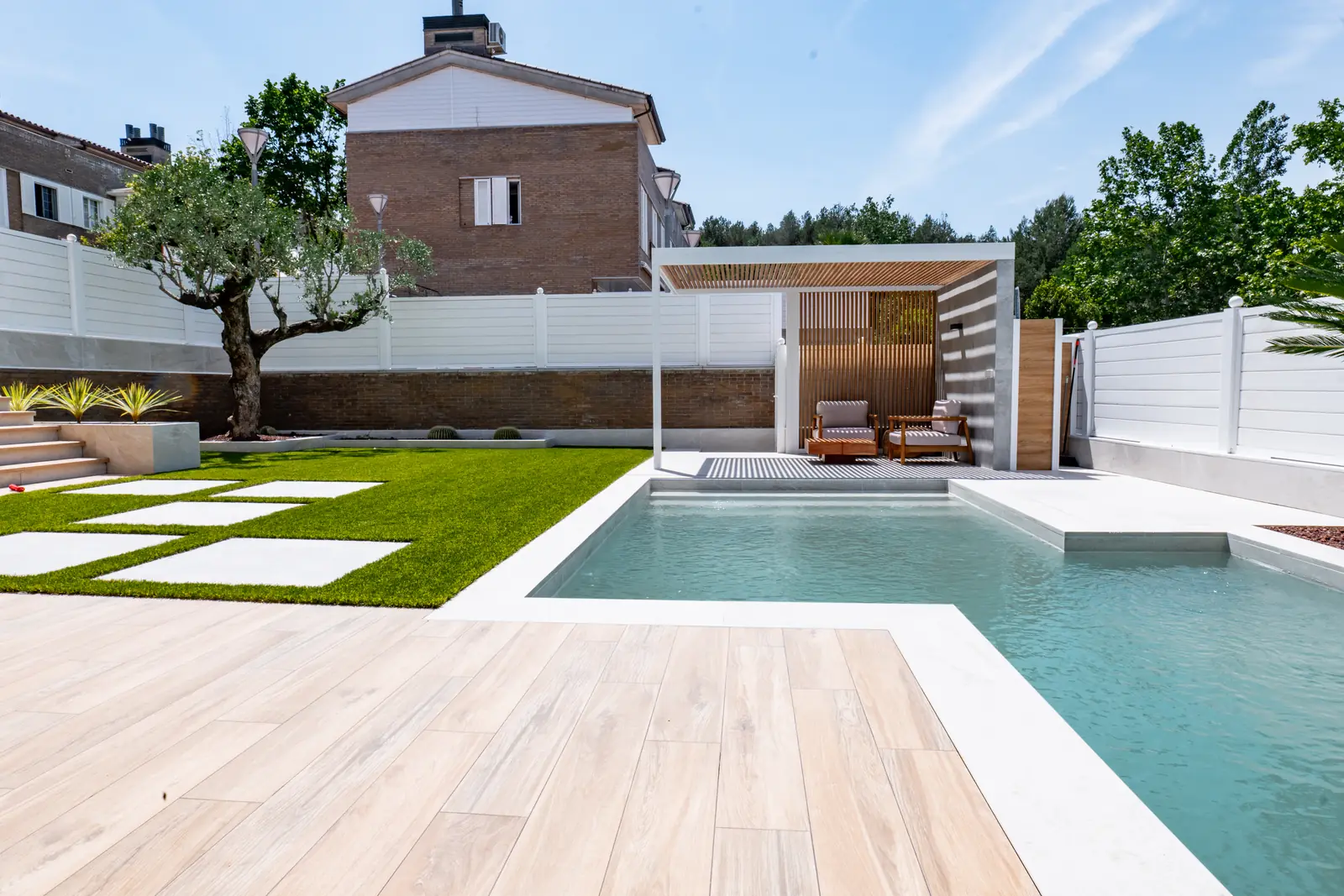 Pérgola blanca con piscina y pavimento exterior