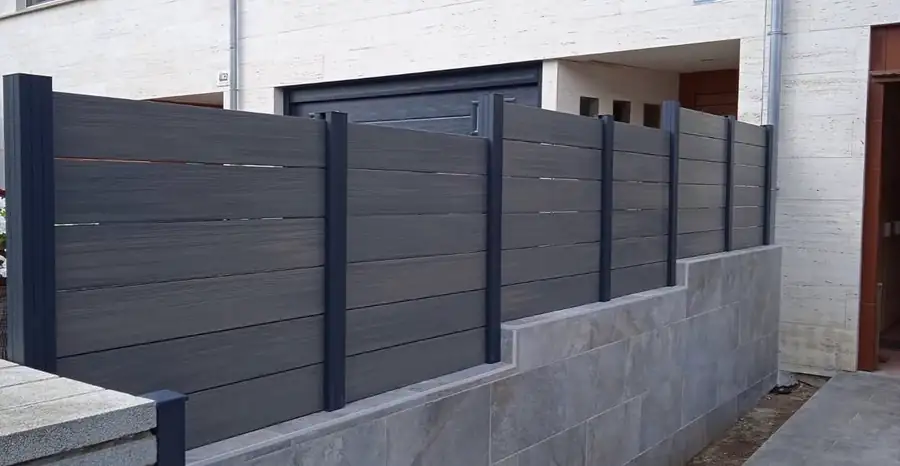 Valla de madera sintética Grey instalada sobre muro exterior