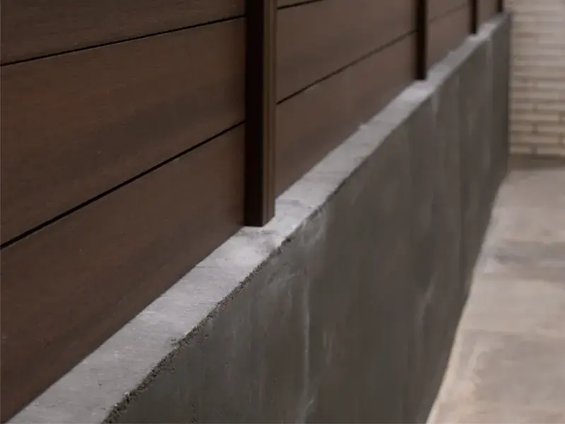 Valla Light Walnut instalada sobre un murete exterior en Terrassa