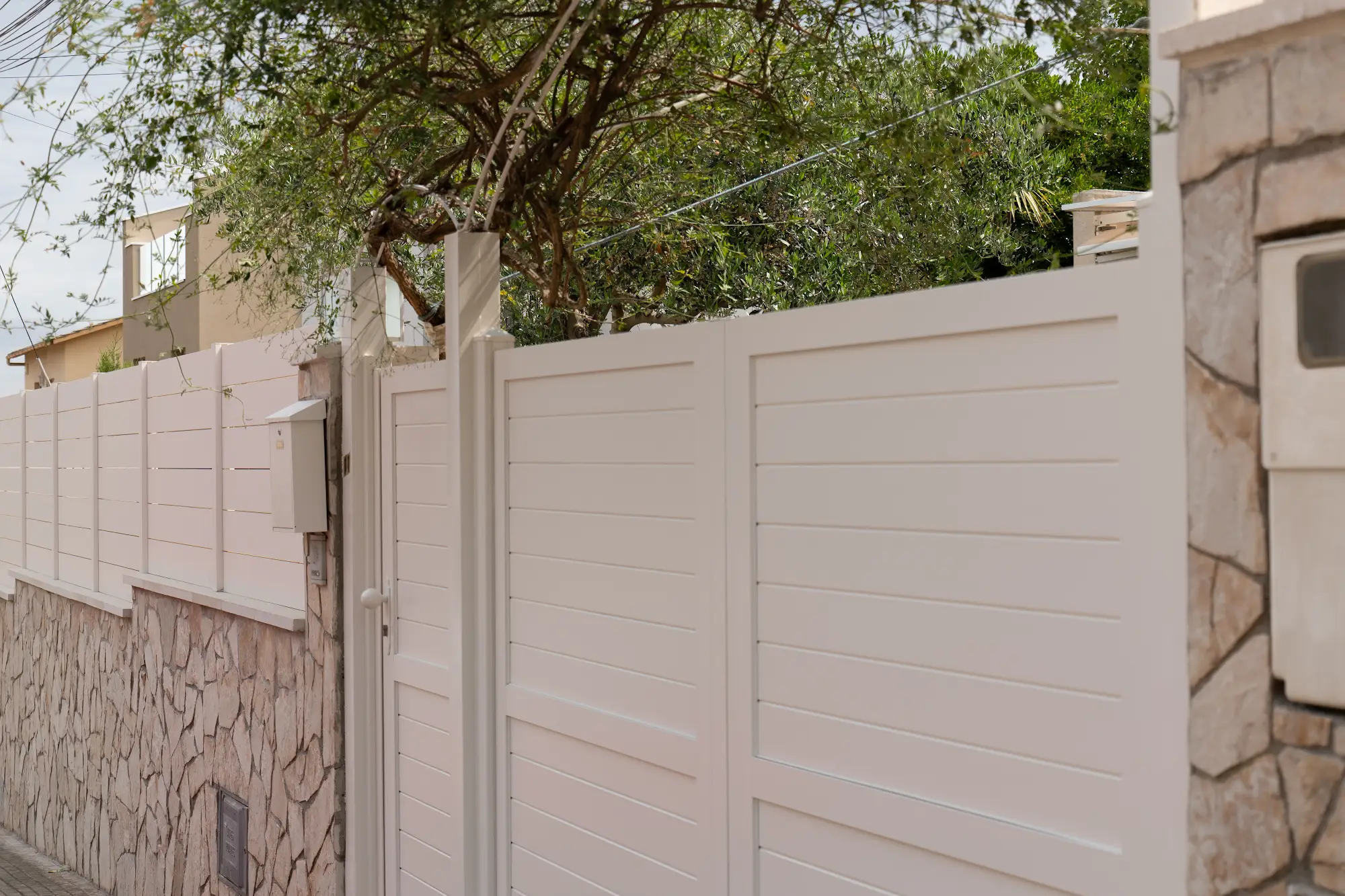 Puerta y valla blanca junto a un acceso exterior