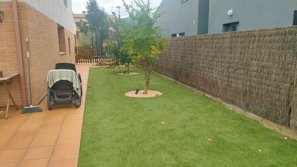 Exterior con césped artificial integrado en espacio de estancia