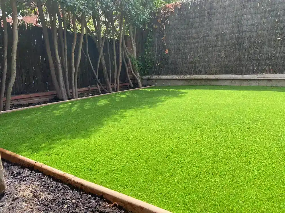 Jardín amplio con césped artificial y arbolado en Manresa