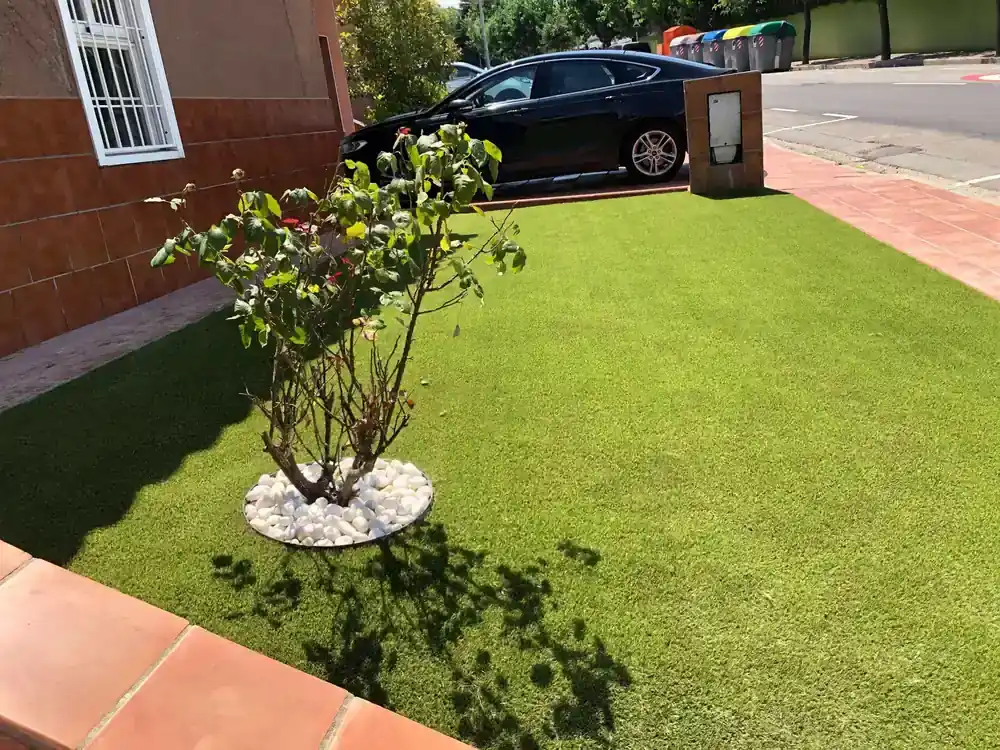 Combinación de césped artificial con grava blanca y pavimento exterior en Rubí