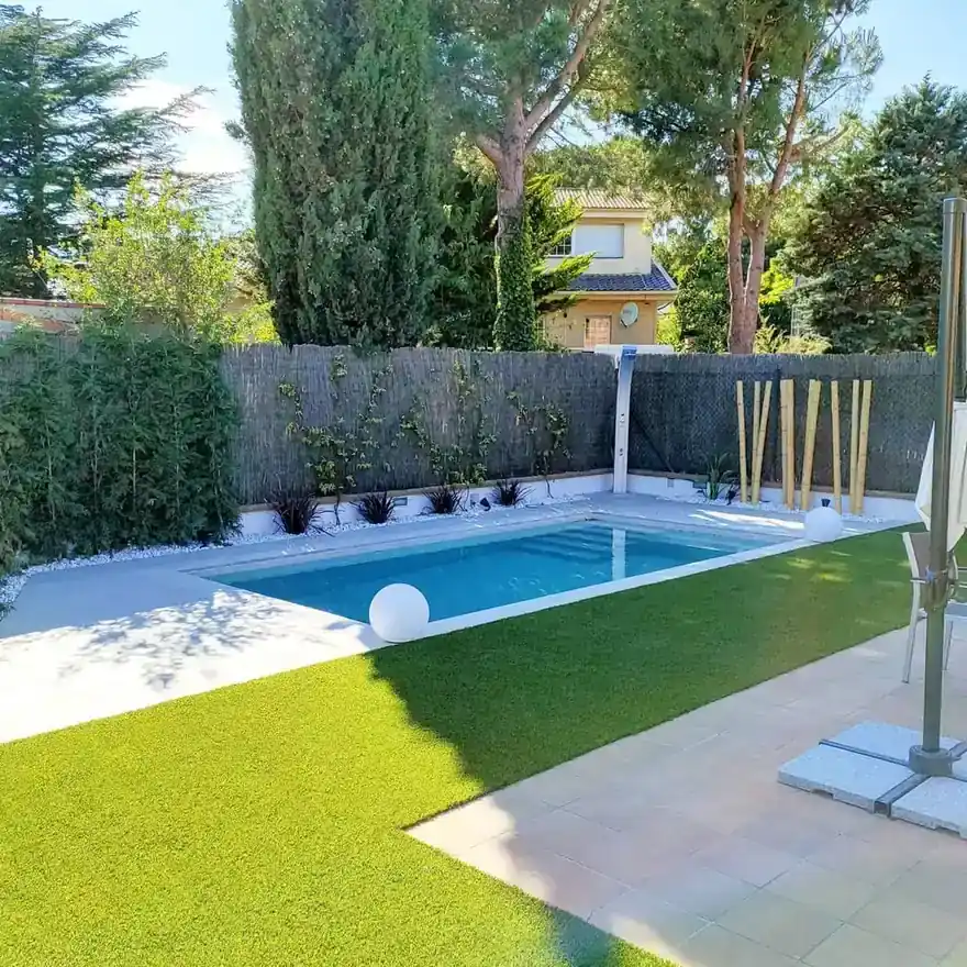 Jardín con piscina, vegetación y bordes minerales dentro de un proyecto paisajístico