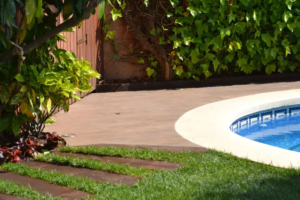 Zona exterior con porcelánico efecto madera y transición hacia piscina