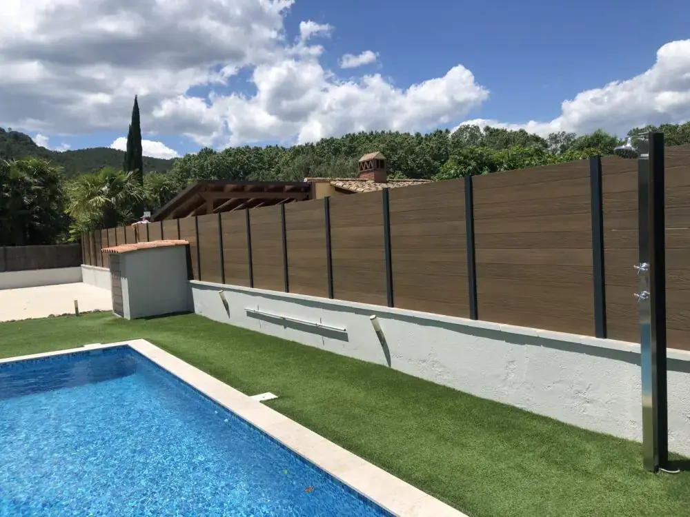 Valla efecto madera junto a piscina y césped artificial